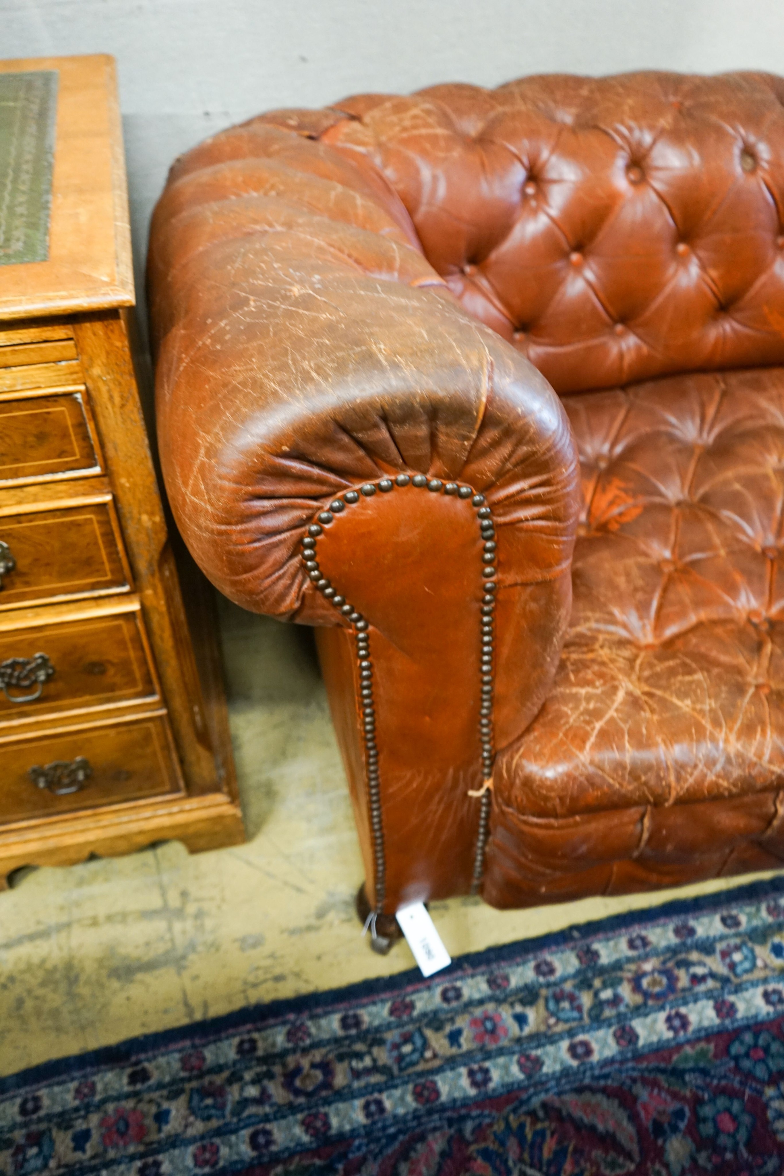 A late Victorian drop arm leather button back Chesterfield settee, length 170cm, depth 88cm, height 70cm